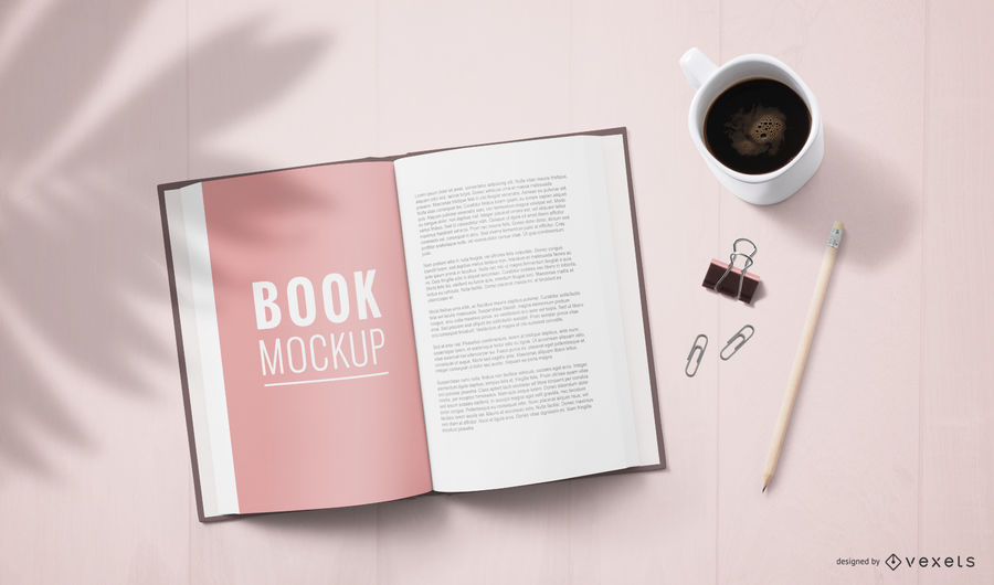 Abra la página del libro con café, clips y maquetas de bolígrafo