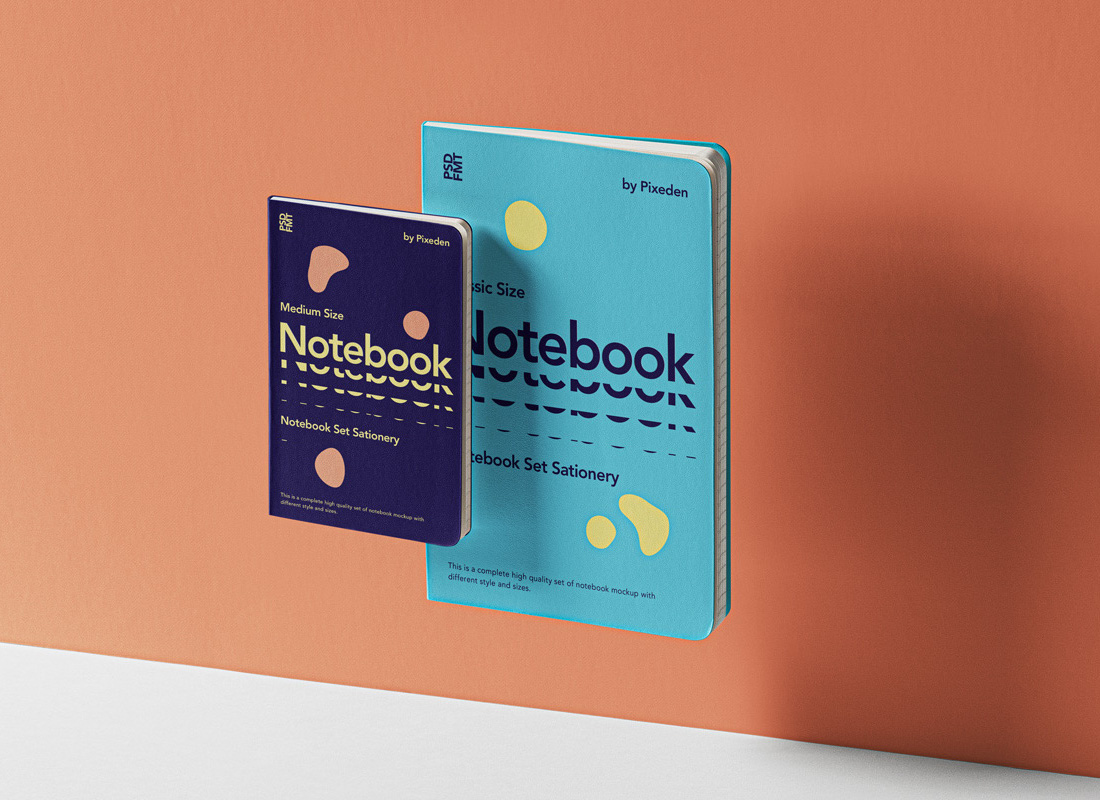 A stylish notebook mockup and a small card leaning against an orange wall, featuring a modern graphic design with playful shapes and contrasting colors.
