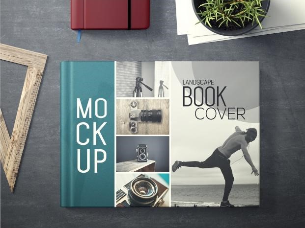 A stylish mockup of a landscape book on a creative workspace, surrounded by photography paraphernalia and office supplies.