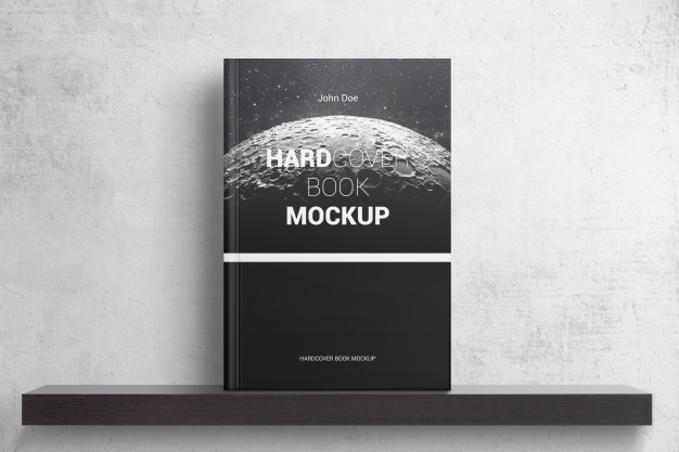 A hardcover book with a moon graphic on the cover displayed on a dark shelf against a textured light gray wall, showcasing a book on shelf design mockup template.