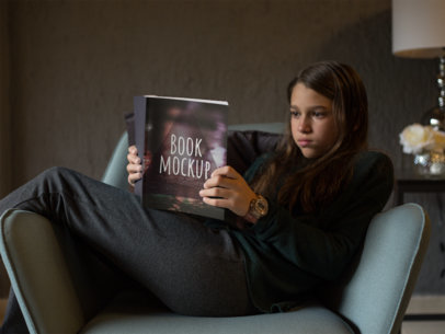 Garota lendo um livro sobre uma poltrona