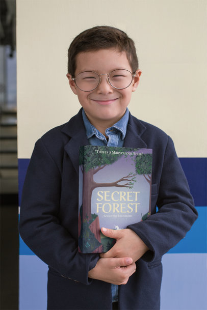 Giovane ragazzo sorridente che tiene un libro