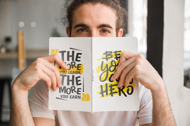 Man Holding Book in Front of His Face