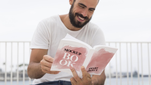 Uomo che sorride durante la lettura del libro