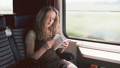 Niña leyendo un libro mientras está en un tren