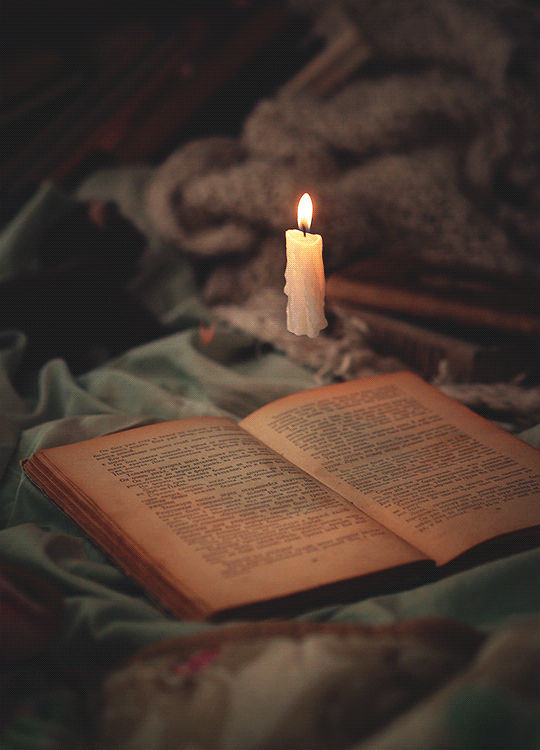 Brennende Kerze, die auf einem offenen Buch schwebt